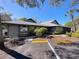 Side view of community clubhouse with parking, trees, and bright blue sky at 39650 Us Highway 19 N # 411, Tarpon Springs, FL 34689