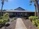 Community clubhouse with well-maintained landscaping, walkway, and blue sky at 39650 Us Highway 19 N # 411, Tarpon Springs, FL 34689