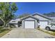 Home exterior featuring a two-car garage, driveway, and well-kept landscaping at 39650 Us Highway 19 N # 411, Tarpon Springs, FL 34689
