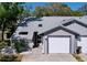 Charming gray home featuring an attached one car garage and well manicured landscaping at 39650 Us Highway 19 N # 411, Tarpon Springs, FL 34689