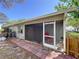 View of the exterior of the house, including the enclosed sunroom and fenced yard at 39650 Us Highway 19 N # 411, Tarpon Springs, FL 34689