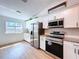 Modern kitchen features stainless steel appliances, including a Samsung microwave, complementing the stylish white cabinetry at 39650 Us Highway 19 N # 411, Tarpon Springs, FL 34689