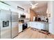 Well-lit kitchen featuring white cabinets, stainless steel appliances, and a view into the adjacent living area at 39650 Us Highway 19 N # 411, Tarpon Springs, FL 34689