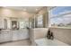 This primary bathroom features double sinks, a soaking tub and a glass enclosed shower with natural light at 4032 Harvest Hearth Pl, Plant City, FL 33565