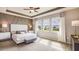 This spacious main bedroom features a decorative wall, ceiling fan, and abundant natural light from the three large windows at 4032 Harvest Hearth Pl, Plant City, FL 33565