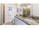 Elegant bathroom featuring double sinks with granite countertops, decorative art, and a glass-enclosed shower, showcasing modern design at 4058 Westwood Fields Loop, Plant City, FL 33565