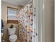 Bathroom features a window, toilet, and whimsical camel-themed shower curtain at 4219 Summerdale Dr, Tampa, FL 33624