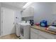 This well-lit laundry room features a washer, dryer, cabinets, and granite countertops at 4219 Summerdale Dr, Tampa, FL 33624
