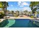 Waterfront backyard featuring a pristine pool, lounge seating, and a serene view of the water at 44 Martinique Ave, Tampa, FL 33606