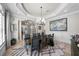 Formal dining room featuring elegant wainscoting, tray ceiling, modern chandelier, and stylish decor at 44 Martinique Ave, Tampa, FL 33606