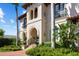 Detailed view of the home's entrance, showcasing the arched doorway, decorative columns, and lush green landscaping at 44 Martinique Ave, Tampa, FL 33606