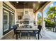 A full outdoor kitchen featuring a built-in grill and elegant travertine floors, perfect for entertaining at 44 Martinique Ave, Tampa, FL 33606