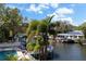 Waterfront backyard featuring a pool, deck, and private dock with boat lift overlooking tranquil waters at 44 Martinique Ave, Tampa, FL 33606