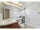Bathroom with a sink, vanity, toilet and shower/tub featuring decorative striped shower curtain at 440 Woods Landing Trl, Oldsmar, FL 34677