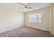 A bright bedroom features neutral walls and carpet, a ceiling fan, and a window with white blinds at 440 Woods Landing Trl, Oldsmar, FL 34677