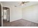 View of a well-lit bedroom showcasing neutral walls and carpet, a ceiling fan, and an open doorway at 440 Woods Landing Trl, Oldsmar, FL 34677