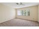 A bedroom with neutral walls and carpet, a ceiling fan, and a window offering an outside view at 440 Woods Landing Trl, Oldsmar, FL 34677
