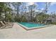 Community pool surrounded by lounge chairs and greenery, providing a relaxing and refreshing space at 440 Woods Landing Trl, Oldsmar, FL 34677