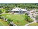 Scenic view of golf course and clubhouse, surrounded by palm trees and lush greenery on a sunny day at 440 Woods Landing Trl, Oldsmar, FL 34677