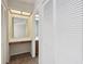 A hallway view, complete with a vanity, a mirror, and large, paneled closet doors at 440 Woods Landing Trl, Oldsmar, FL 34677