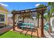 Backyard patio featuring a pergola, outdoor kitchen, grill, and palm trees at 4421 5Th S Ave, St Petersburg, FL 33711