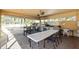 Covered outdoor kitchen and dining area with a grill, sink, stainless steel countertops, and beautiful backyard views at 4460 Fairways Blvd # 401, Bradenton, FL 34209