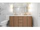 Bright bathroom featuring double vanity with gold fixtures, arched mirrors, and marble accent wall at 5011 S Elberon St, Tampa, FL 33611