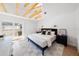 Inviting bedroom with exposed wooden beams, access to a private balcony, and stylish furnishings at 5011 S Elberon St, Tampa, FL 33611