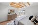 Comfortable bedroom featuring a dresser, balcony access, hardwood floors, and exposed wooden beams at 5011 S Elberon St, Tampa, FL 33611