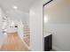 Bright foyer featuring hardwood floors, white staircase and convenient powder room at 5011 S Elberon St, Tampa, FL 33611
