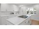 Bright white kitchen with modern appliances and a center island cooktop at 5011 S Elberon St, Tampa, FL 33611