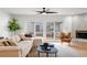 Cozy living room boasts a plush sofa, stylish furnishings, and sliding glass doors with pool views at 5011 S Elberon St, Tampa, FL 33611