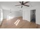 Spacious living room with hardwood floors, ceiling fan, and view of bathroom with tiled walk-in shower at 5011 S Elberon St, Tampa, FL 33611