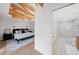 Main bedroom with exposed wooden beams features hardwood floors, and an ensuite bath with a glass shower at 5011 S Elberon St, Tampa, FL 33611