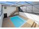 A relaxing pool area with wooden decking, an open-air enclosure, and stairs that lead to another part of the home at 5011 S Elberon St, Tampa, FL 33611