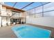 A beautiful pool area with a wood deck and an open-air screened-in enclosure with a balcony overhead at 5011 S Elberon St, Tampa, FL 33611