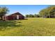 Red barn sitting in a spacious green field surrounded by lush greenery at 5305 Coronet Rd, Plant City, FL 33566