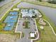 An aerial view of the community clubhouse amenities, including tennis courts, pool, playground, and parking areas at 5407 Tagalong Pl, Apollo Beach, FL 33572