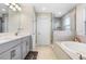 Primary bathroom featuring dual sinks, bathtub and a standing shower at 5407 Tagalong Pl, Apollo Beach, FL 33572