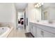Primary bathroom with double sink vanity and soaking tub with tile surround at 5407 Tagalong Pl, Apollo Beach, FL 33572