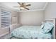 Bright bedroom features a ceiling fan, window with blinds, and a comfortable bed at 5407 Tagalong Pl, Apollo Beach, FL 33572