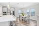 Open-concept kitchen and dining area, illuminated by modern pendant lights and natural light from large windows at 5407 Tagalong Pl, Apollo Beach, FL 33572