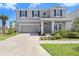 Charming two-story home featuring a manicured lawn, attached garage, and covered front porch with stately columns at 5407 Tagalong Pl, Apollo Beach, FL 33572