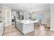 Well-lit kitchen featuring an island with bar seating, stainless steel appliances, and stylish gray cabinetry at 5407 Tagalong Pl, Apollo Beach, FL 33572