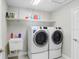 Modern laundry room features a sink, storage shelves and front load washer and dryer at 5407 Tagalong Pl, Apollo Beach, FL 33572