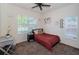 Cozy bedroom featuring plush carpet, a ceiling fan, and ample natural light from the window at 6264 Dorset Rd, Spring Hill, FL 34608