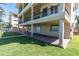 Back yard with manicured lawn, brick patio, outdoor space under the elevated deck, and beautiful landscaping at 700 126Th Ave, Treasure Island, FL 33706