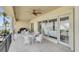 Expansive covered balcony has water views, a dining set, grill, and columned supports at 700 126Th Ave, Treasure Island, FL 33706