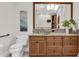 Bathroom featuring granite counters, wood cabinets, framed mirror and decorative wall art at 700 126Th Ave, Treasure Island, FL 33706