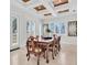 Formal dining room with tray ceiling, plantation shutters, artwork, and seating for eight at 700 126Th Ave, Treasure Island, FL 33706